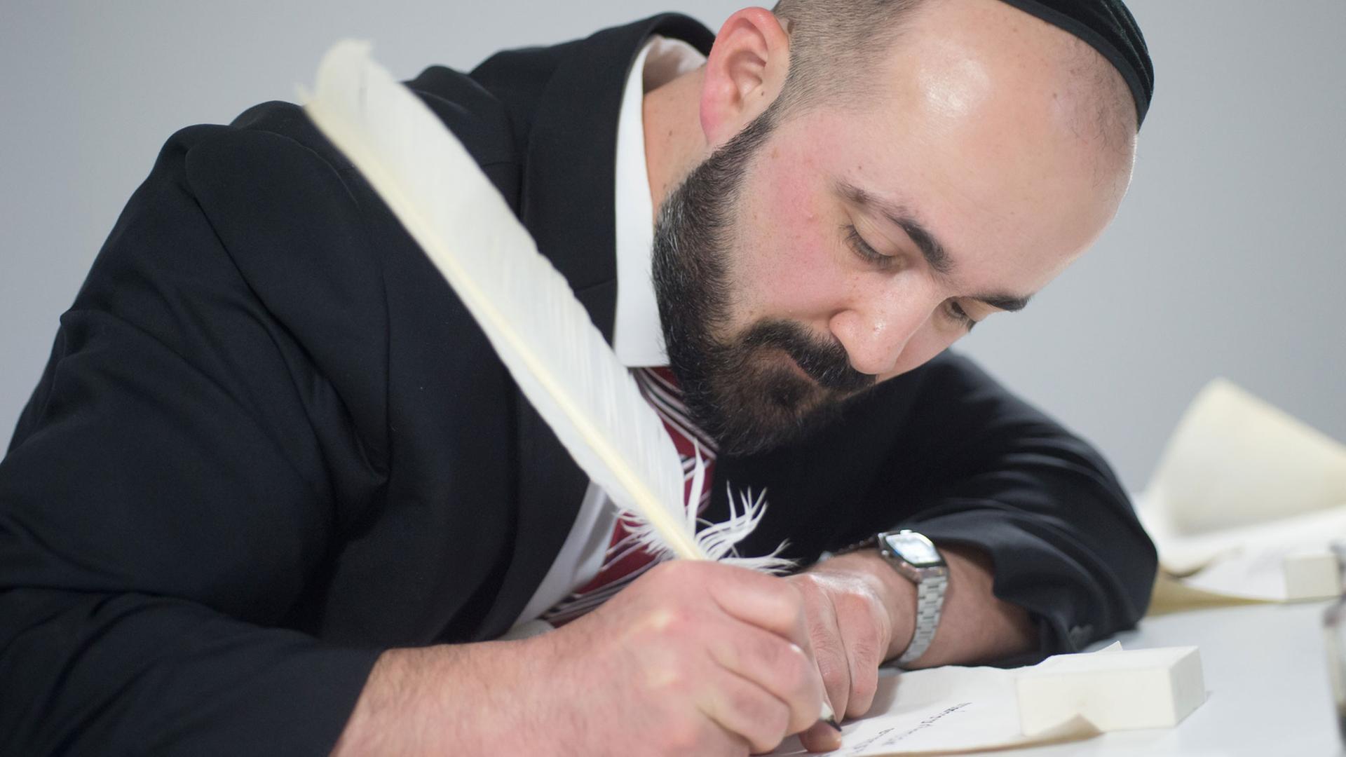 Der Berliner Rabbiner Reuven Yaacobov demonstriert am 03.04.2014 im Jüdischen Museum Berlin in der Ausstellung "Die Erschaffung der Welt", wie eine Thorarolle gemäß der überlieferten Vorschriften geschrieben wird.