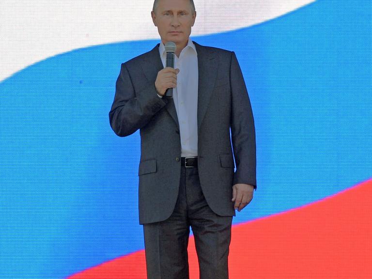 Präsident Wladimir Putin vor einer russischen Flagge.