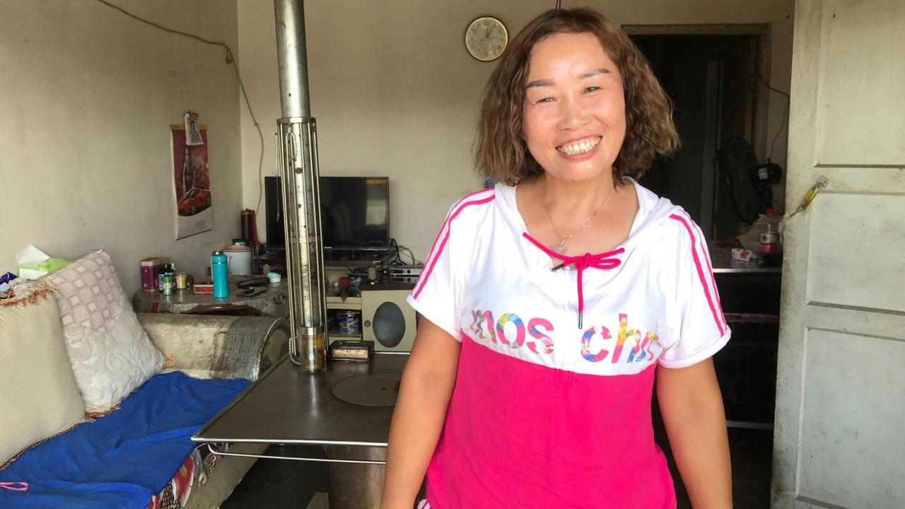 Die 49-jährige Bäuerin lebt mit ihrem Mann und vier Kindern rund eine Auto-Stunde außerhalb der Provinzhauptstadt Guiyang und ist froh über die neuen Firmen in der Gegend. Sie lächelt und trägt ein rosa T-Shirt.