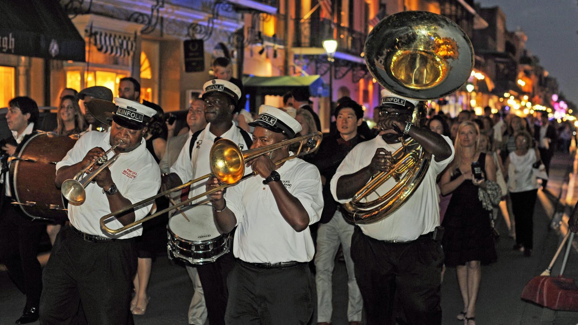 Eine Jazzkapelle zieht abends durch die Strassen im historischen Viertel French Quarter von New Orleans