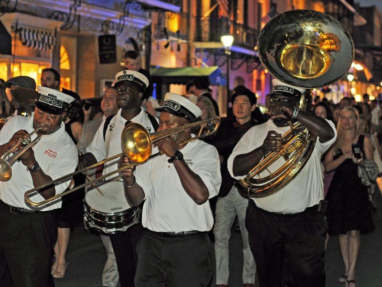 Eine Jazzkapelle zieht abends durch die Strassen im historischen Viertel French Quarter von New Orleans