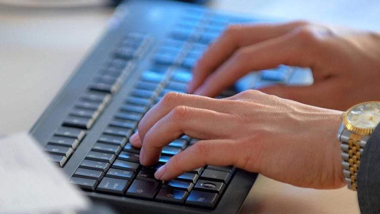 Eine Frau arbeitet an einer Computer-Tastatur.