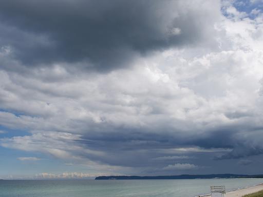 Wolkenverhangener Himmel über einem Strand 