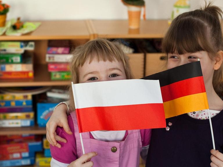 Im deutsch-polnischen Eurokindergarten in Frankfurt (Oder) umarmen sich die Freundinnen Domenika Rzeznikiewicz (l) aus Polen und Mara Behnke aus Deutschland.