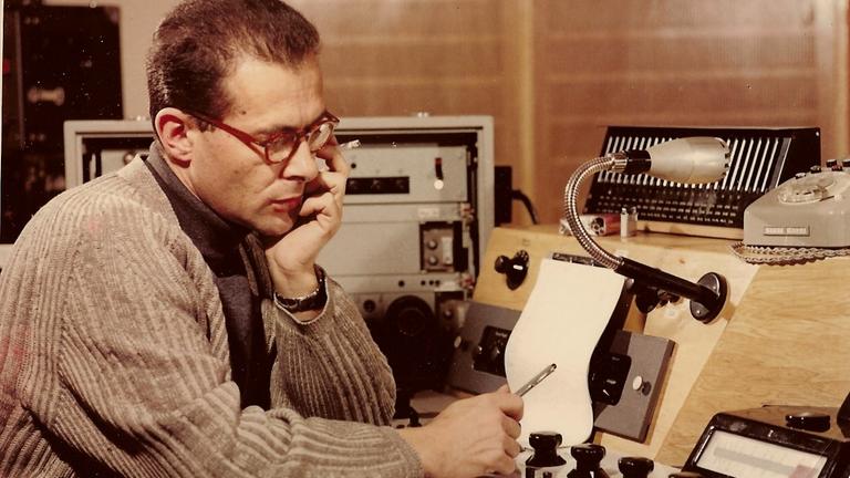 Herbert Brün mit Zigarette und Notizen am Pult im Elektronischen Studio
