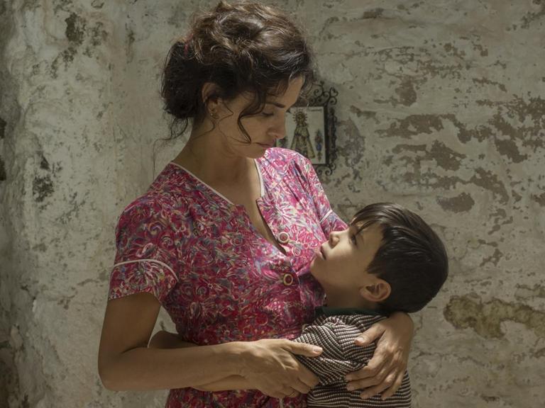 Die Schauspieler Penélope Cruz und Asier Flores in einer liebevollen Filmszene, in der die Mutter ihren kleinen Sohn umarmt.