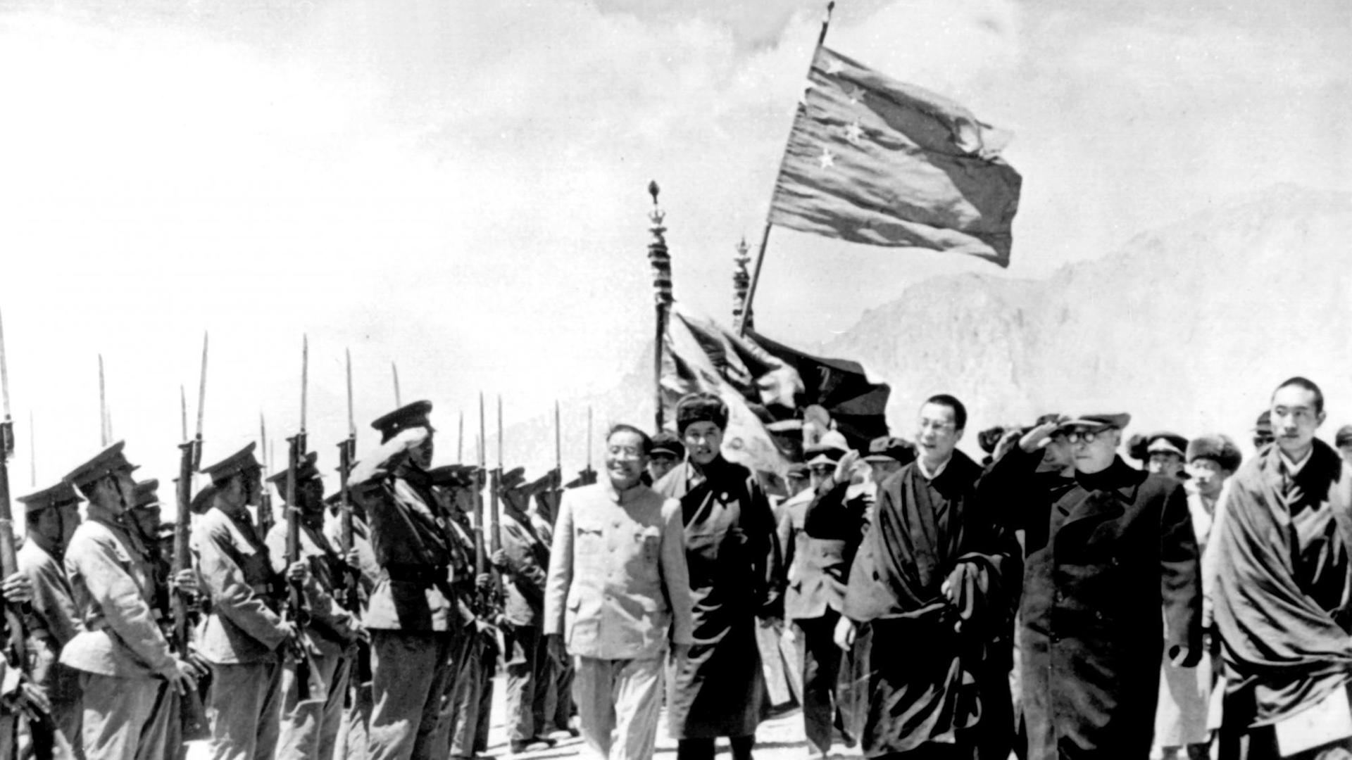 Mai 1965: Der Leiter der chinesischen Delegation, der stellvertretende Ministerpräsident Chen Yi (2.v.r.), schreitet mit dem Dalai Lama zu seiner Rechten und dem Pantschen Lama zu seiner Linken eine tibetanische Ehrengarde ab, nachdem Tibet zur Autonomen Region erklärt wurde.