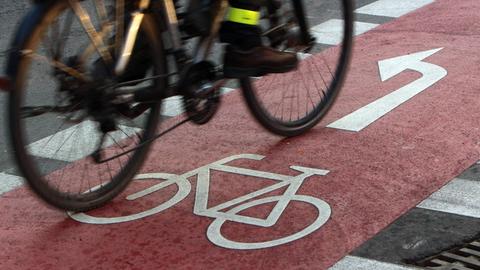 Ein Radfahrer befährt einen farblich abgesetzten Radweg auf der Kaiserstraße in der Innenstadt von Karlsruhe.