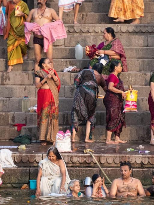 Menschen baden im Wasser des Ganges, eine heilige und reinigende Handlung in der Hindu Religion. Varanasi, Indien, 2018.