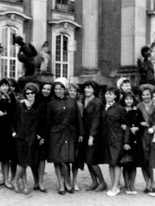 Ein historische Foto auf dem mehrere Frauen auf einer Straße stehen.