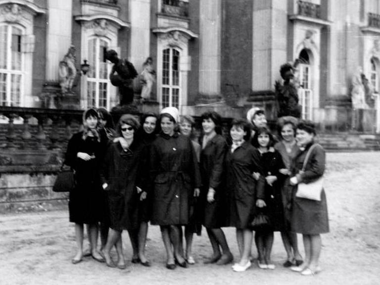 Ein historische Foto auf dem mehrere Frauen auf einer Straße stehen.