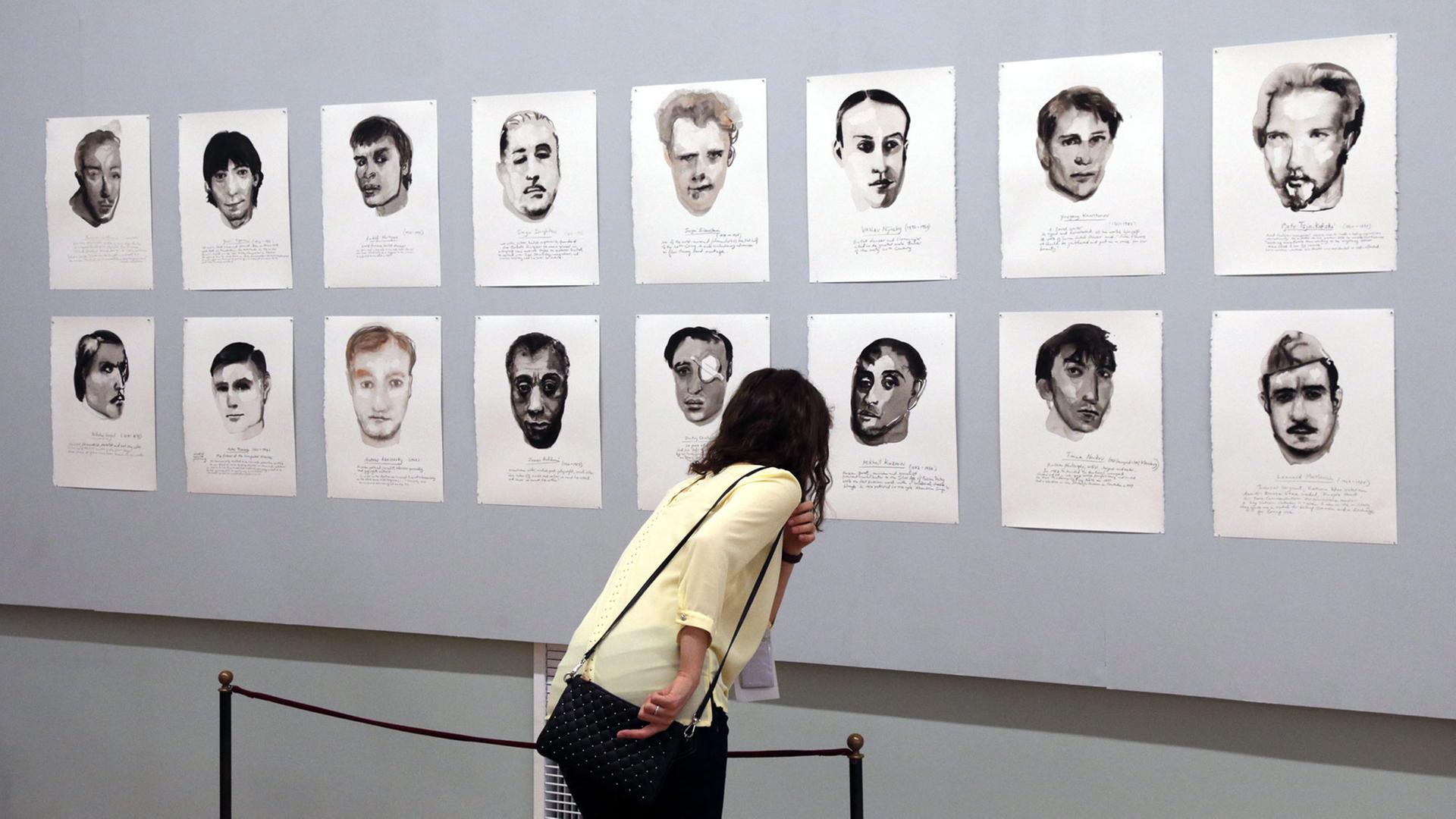 Eine Besucherin betrachtet am 27.6.2014 die Serie "Great Men" der niederländischen Künstlerin Marlene Dumas bei der "Manifesta 10" in St. Petersburg, Russland: Porträts von berühmten homosexuellen Künstlern und Kulturschaffenden.