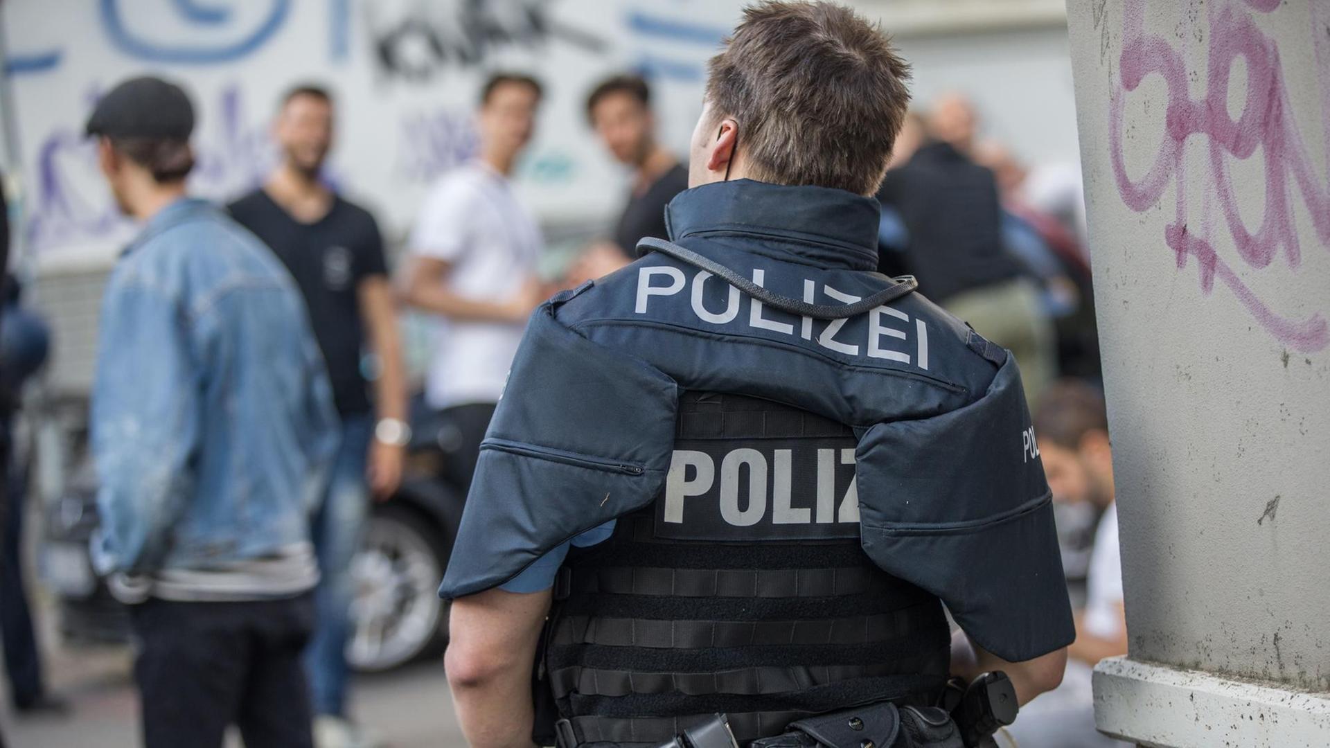 Polizisten bewachen eine Gruppe festgesetzter junger Männer in Darmstadt.