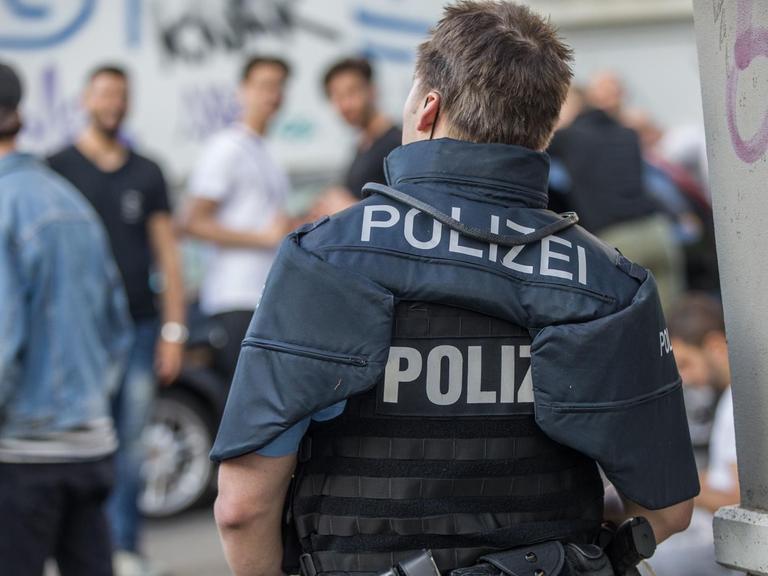 Polizisten bewachen eine Gruppe festgesetzter junger Männer in Darmstadt.