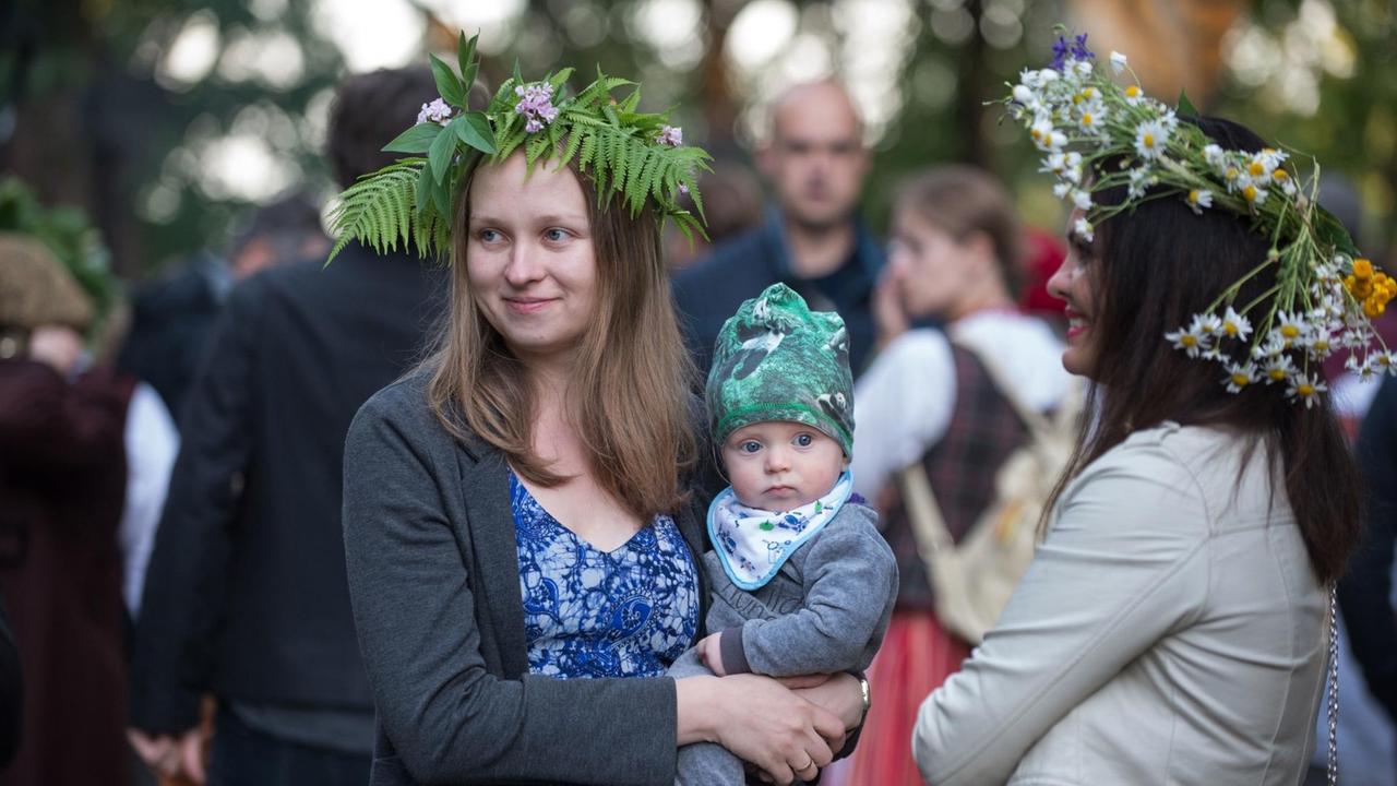 Frauen in traditioneller Kleidung und Blumenkränzen auf dem Kopf beim Rasos Festival in Vilnius.