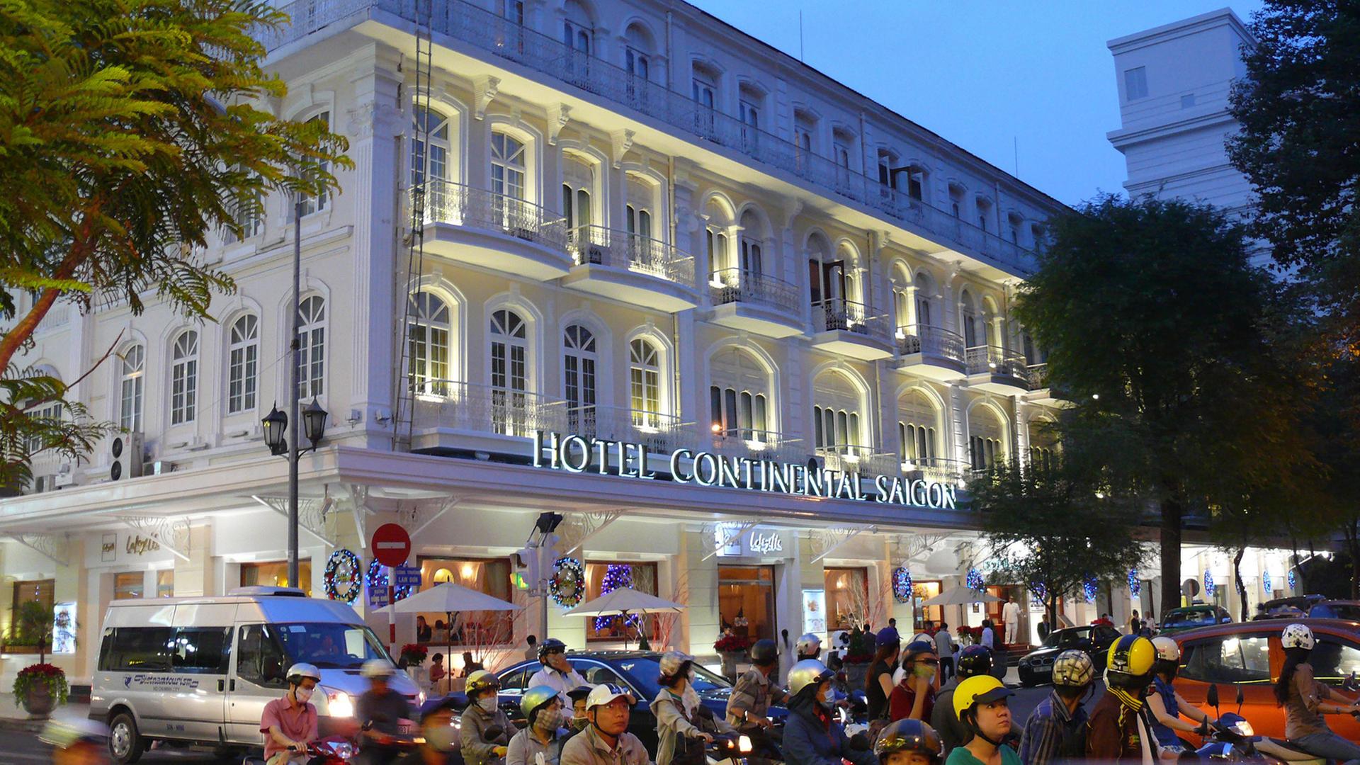 Das legendäre Hotel Continental an der Dong Khoi Street im District 1 in der südvietnamesichen Metropole Ho-Chi-Minh-Stadt wird vom abendlichen Mopedverkehr umbraust.