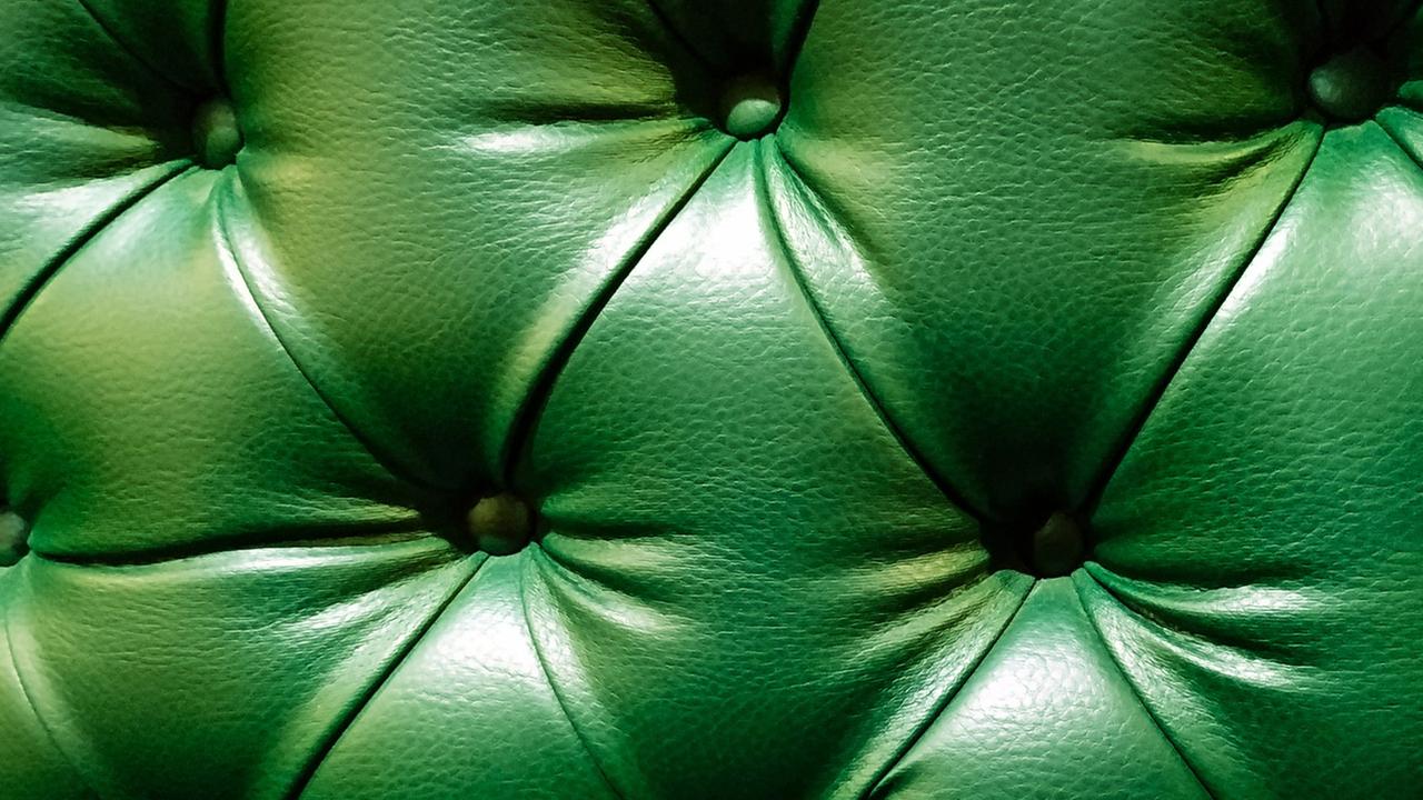 eine grüne Rückenlehne eines Sessels oder eines Sofas aus Kunstleder.