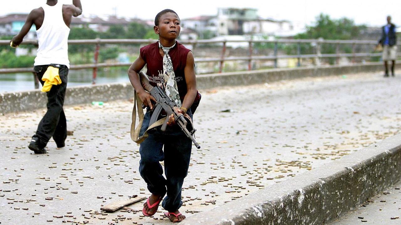 ACHTUNG: SPERRFRIST 7. SEPTEMBER 16:00 UHR. - ACHTUNG SPERRFRIST 07.09.2017, 16:00 UHR. ARCHIV - ILLUSTRATION - Ein Kindersoldat der liberianischen Armee, der für den damaligen Präsidenten Charles Taylor kämpft, geht am 30.07.2003 mit einer Schußwaffe durch die Hauptstadt Monrovia (Liberia). (zu dpa «UN: Armut und Marginalisierung treiben junge Afrikaner zu Extremismus» vom 07.09.2017) Foto: epa Nic Bothma/EPA_FILES/dpa