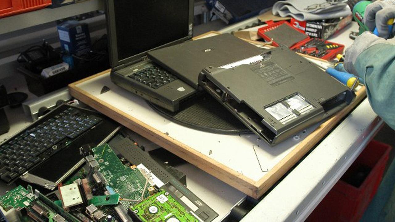 Ein Arbeiter entnimmt einem Laptop Wertstoffe wie Edelmetalle zur Wiederverwertung. Ein Arbeiter entnimmt einem Laptop Wertstoffe wie Edelmetalle zur Wiederverwertung.