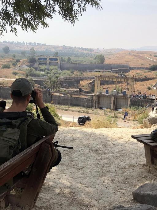 Ein israelischer Soldat sitzt an der Grenze blickt in Richtung Jordanien