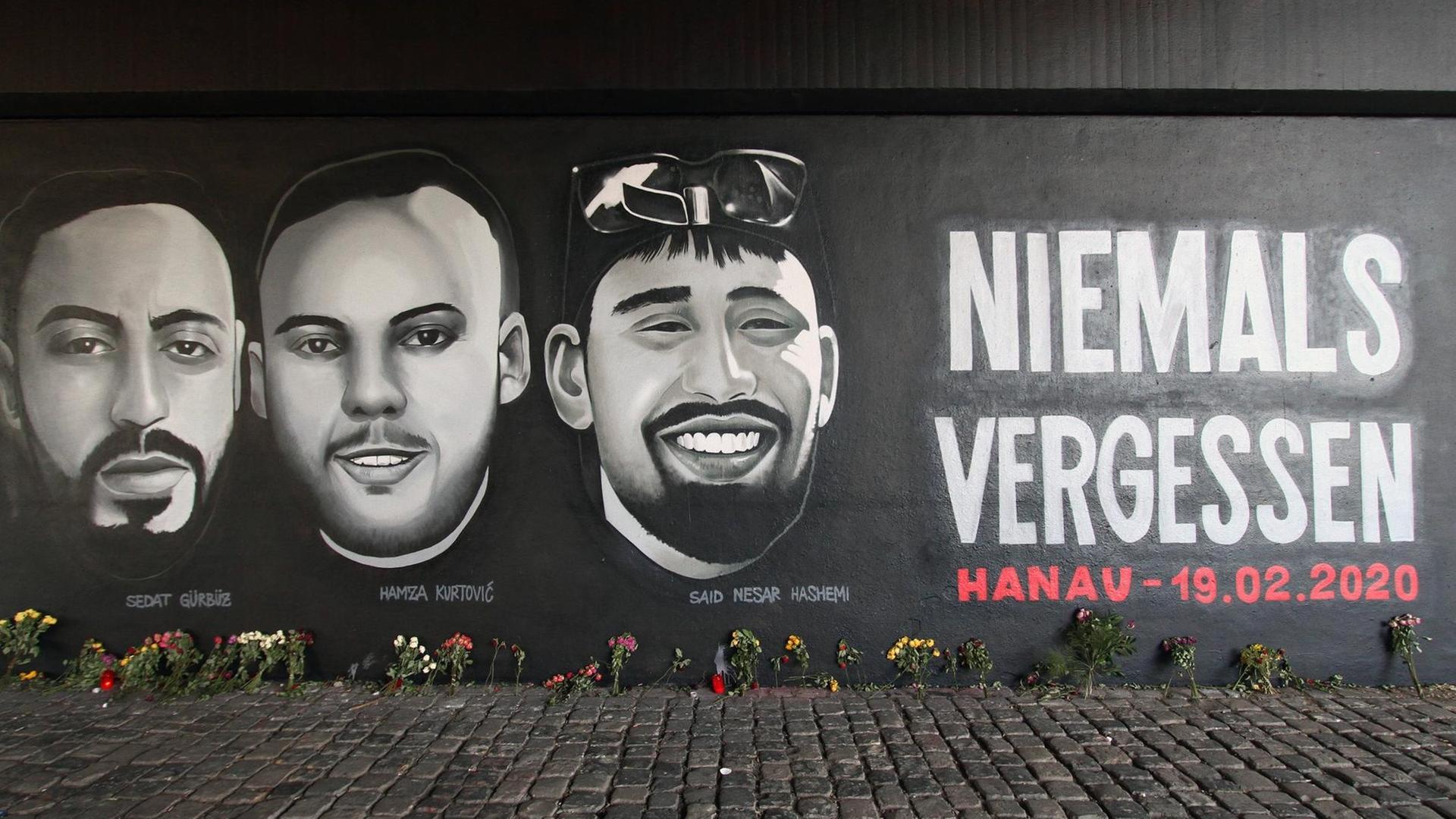 Ein Wandgemälde mit dem Schriftzug „Niemals Vergessen - Hanau 19.02.2020“ und den Porträts der Mordopfer des Anschlags, hier ein Ausschnitt aus dem Gemälde in Frankfurt am Main.
