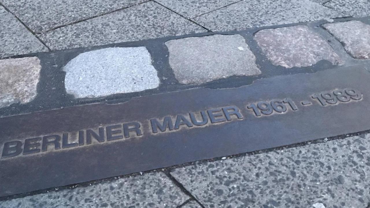 Hier verlief die Berliner Mauer: Ein Gedenkstein mit den Jahreszahlen 1961- 1989 zeigt an, an welcher Stelle sich die Mauer befunden hat.