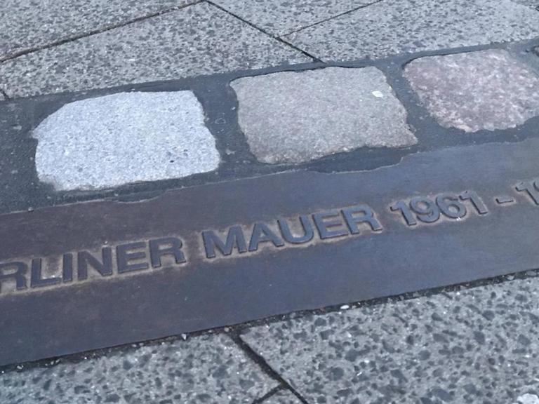 Hier verlief die Berliner Mauer: Ein Gedenkstein mit den Jahreszahlen 1961- 1989 zeigt an, an welcher Stelle sich die Mauer befunden hat.
