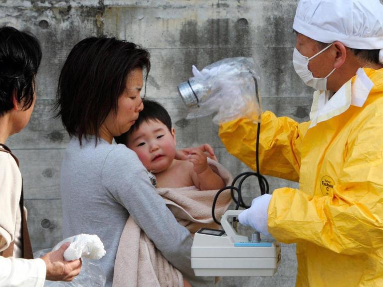 Eine Mutter und ihr Kind werden nach dem Atomunfall von Fukushima im März 2011 auf radioaktive Strahlung untersucht.