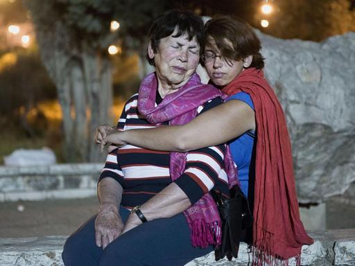 Holocaustueberlebende Pnina Katzir wird von ihrer Enkelin Yael im Sitzen umarmt, beide haben die Augen geschlossen. Jerusalem