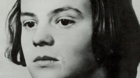 Ein Schwarzweiß-Foto zeigt eine vielleicht 15-jährige Frau mit ernsten Blick in die Kamera schauend
