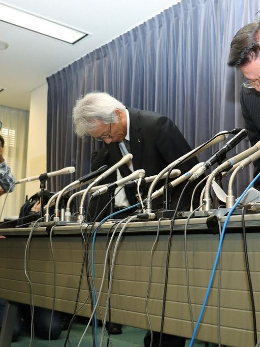 Mitsubishi-Chef Tetsuo Aikawa (r.) und sein Stellvertreter Ryugo Nakao entschuldigen sich für den Manipulationsskandal mit einer in Japan üblichen tiefen Verbeugung.