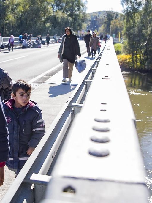 Migranten überqueren am 21.10.2015 den Fluss Mur nahe Spielberg/Österreich, nachdem rund 1.000 Flüchtlinge die Grenze an der Sammelstelle an der slowenisch-österreichischen Grenze durchbrochen hatten.