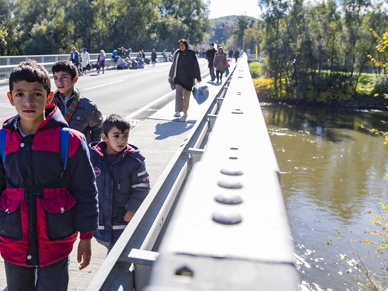 Migranten überqueren am 21.10.2015 den Fluss Mur nahe Spielberg/Österreich, nachdem rund 1.000 Flüchtlinge die Grenze an der Sammelstelle an der slowenisch-österreichischen Grenze durchbrochen hatten.