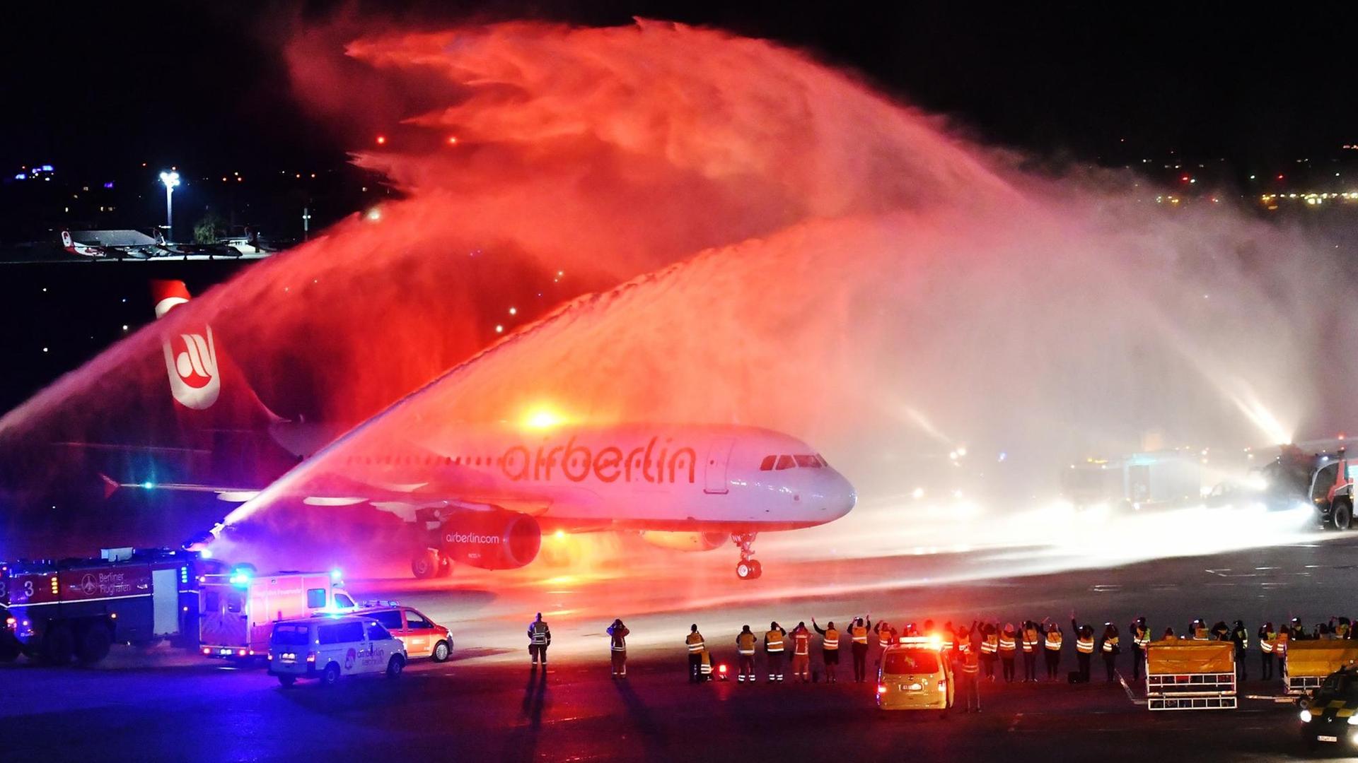 Die letzte Maschine der Fluggesellschaft Air Berlin ist am Abend des 27.10.2017 in Berlin nach ihrem Flug von München auf dem Flughafen Tegel gelandet und wird von der Feuerwehr auf dem Rollfeld mit Wasserfontänen empfangen.