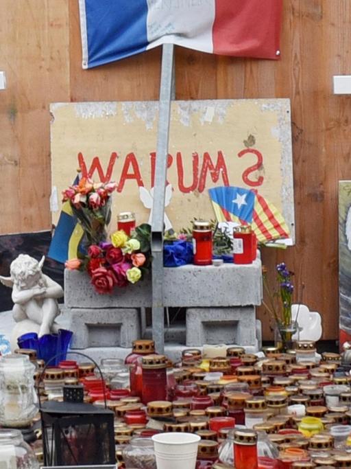 Kerzen und Kreuze stehen vor der Gedenkstelle für die Opfer des Anschlags auf dem Breitscheidplatz in Berlin. Unter dem Schriftzug "Warum" ist auch eine Fahne Kataloniens als Beileidsbekundung für den Terroranschlag in Barcelona zu sehen.