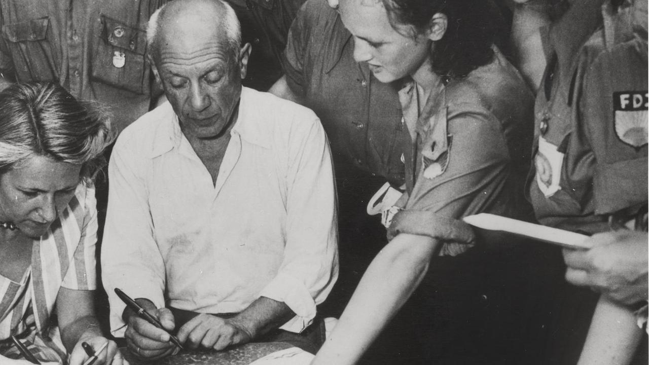 Picasso signiert Mitgliedern der Freien Deutschen Jugend (FDJ) von ihm gestaltete Tücher auf dem internationalen Jugendkongress in Nizza 1950.