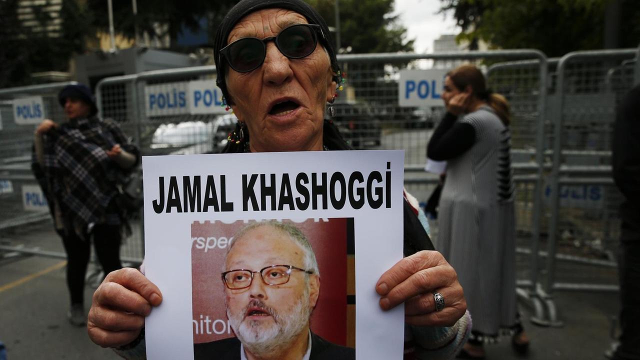 Ein Mann hält ein Foto von Journalist Jamal Khashoggi hoch.
