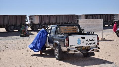 Warten auf den Zug der Erzbahn in Nouadhibou. Die Grenzpolizei überwacht alles, da hinter dem Zug die Westsahara beginnt.