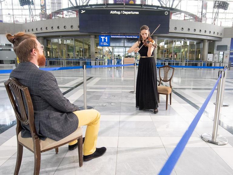 Eine Geigerin spielt für einen einzigen Zuschauer im Flughafen Stuttgart.