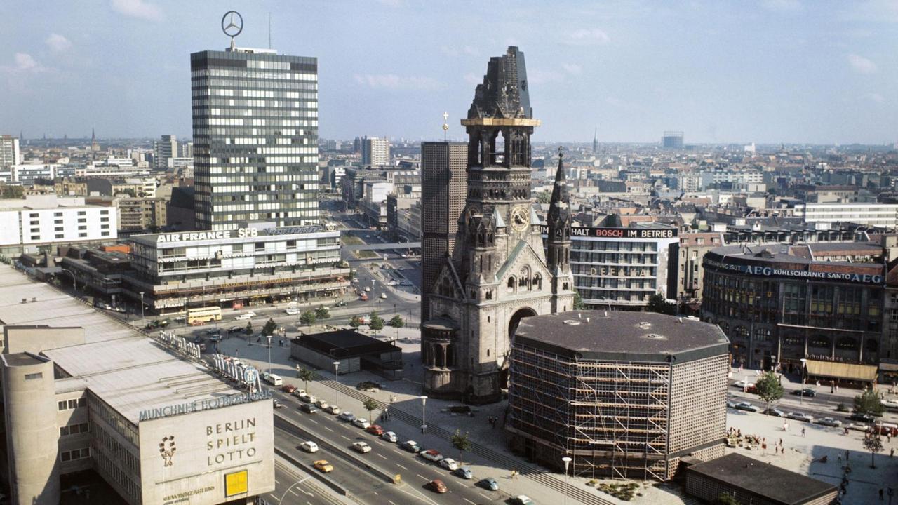 Blick auf den Breitscheidplatz in den 80er-Jahren mit der Ruine der Kaiser Wilhelm Gedächtniskirche, direkt dahinter der Eiermann-Turm und das Hochhaus des Europa-Centers mit dem Mercedes-Stern.