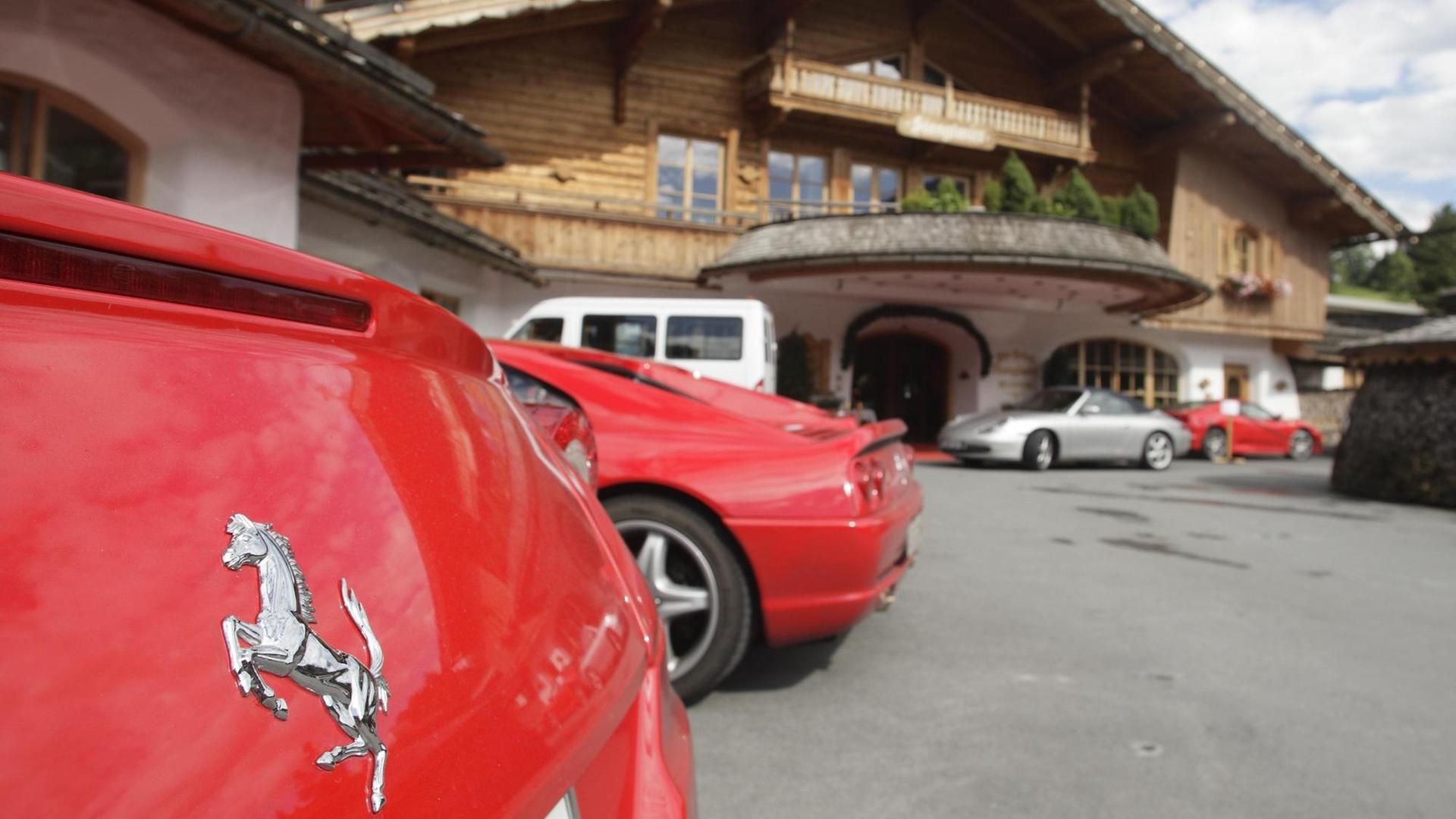 Ansammlung von roten Ferrari Autos auf dem Parkplatz vom 5 Sterne Bio- und Wellnesshotel Stanglwirt in Going, Tirol, Österreich