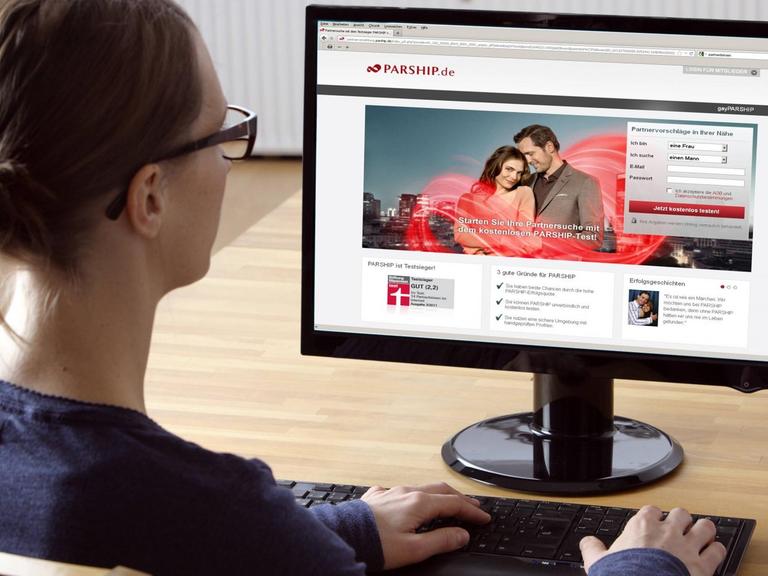 Frau sitzt am Computer, surft im Internet in einem Onlinedating-Portal