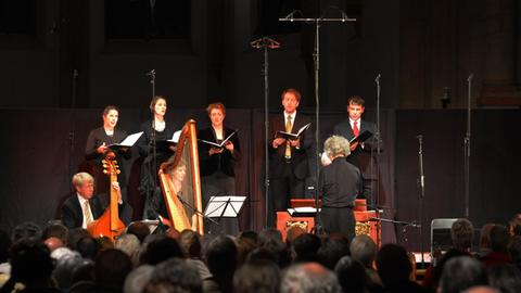 Der Dirigent Hermann Max und Mitglieder der Ensembles Rheinische Kantorei und Das Kleine Konzert in der Basilika Knechtsteden