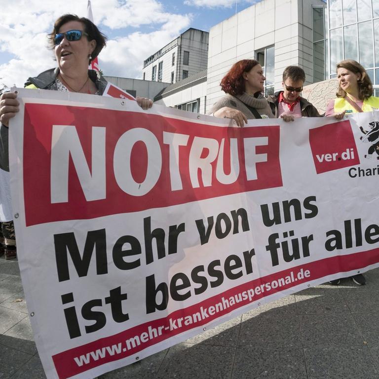 "Notruf: Mehr von uns ist besser für alle!" steht bei einer Demonstration von streikendem Pflegepersonal an der Berliner Charite - Campus Virchow Klinikum auf einem Transparent.