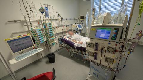 Ein Patient liegt während seines Aufenthalt im Krankenhaus Großhadern in einem Intensivzimmer an einem Beatmungsgerät und einem Dialysegerät.