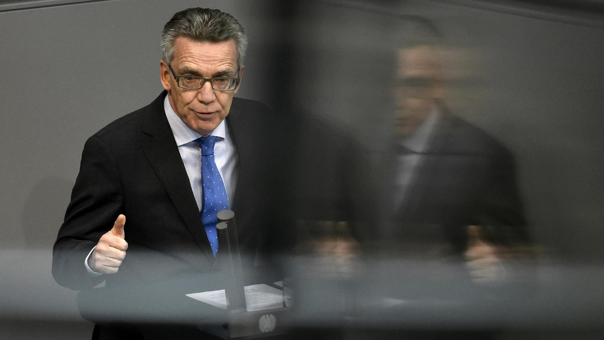 De Maizière steht am Redner-Pult im Deutschen Bundestag.