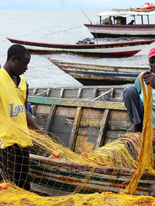 Fischer reparieren ihre Netze am Ufer des Viktoria Sees in Tansania.