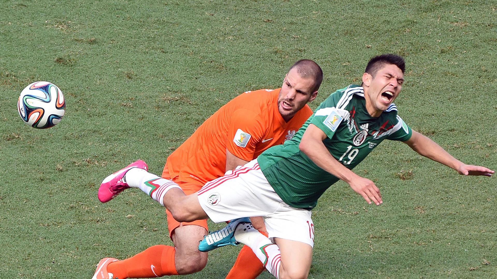 Der Mexikaner Oribe Peralta fällt vor dem Niederländer Ron Vlaar. Der Mexikaner Oribe Peralta fällt vor dem Niederländer Ron Vlaar.