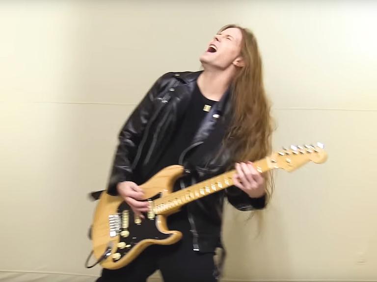 Jered Threatin in seinem Musikvideo mit Gitarre.