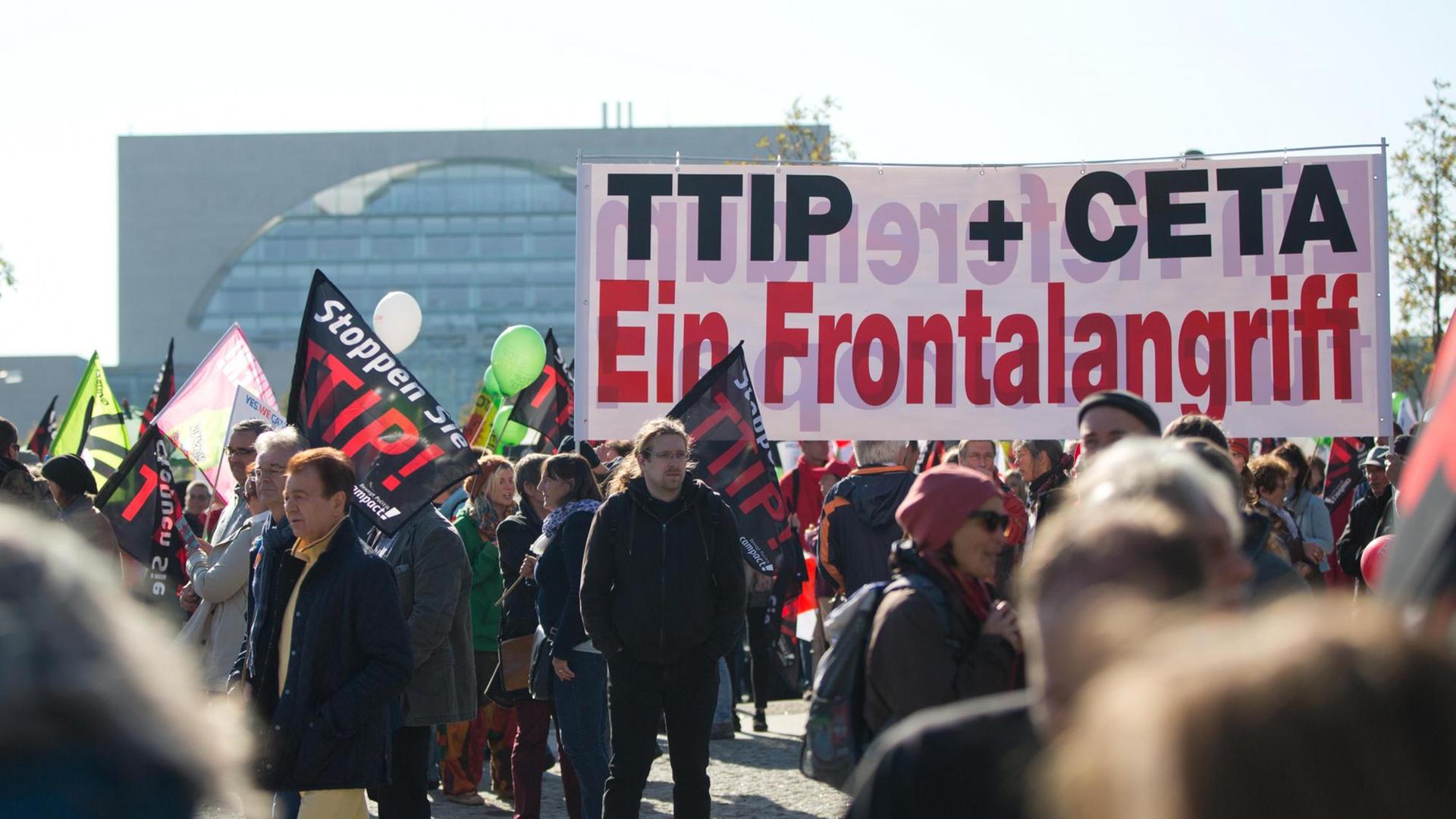 Ein Transparent mit der Aufschrift "TTIP + CETA Ein Frontalangriff" ist bei einer Demonstration gegen das transatlantische Handelsabkommen TTIP (USA) und Ceta (Kanada) am 10.10.2015 in Berlin zu sehen.